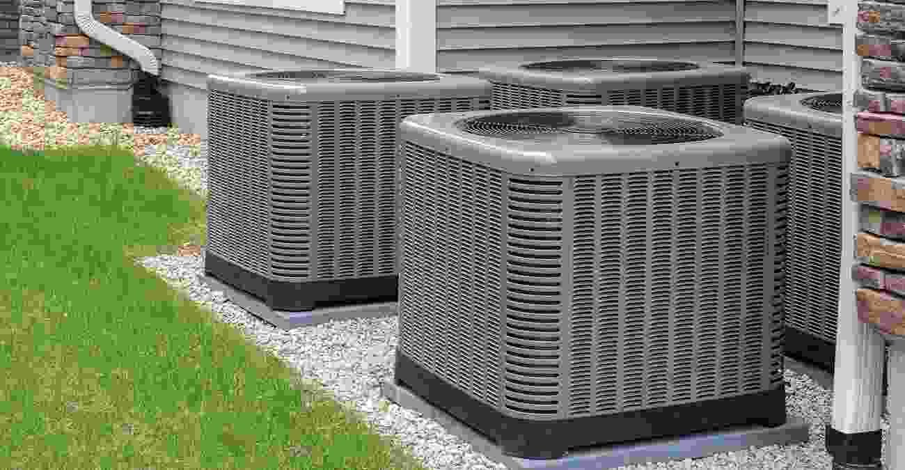 Air conditioning units installed outside a house, emphasizing the importance of regular maintenance and servicing for optimal performance.